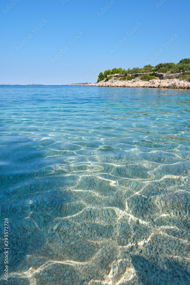 Crystal clear blue green Adriatic sea and a rocky beach on the island Krk, Croatia,