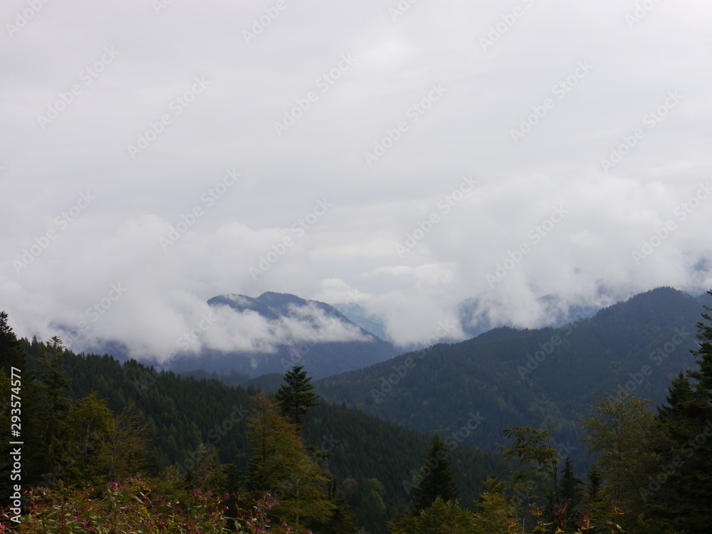 big clouds covering the panoramic view of the mountains and their autumnal forests