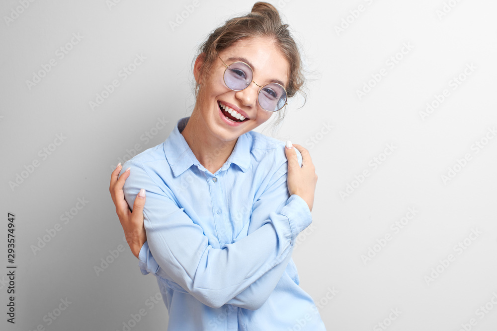 Portrait friendly smiling Kazakh Asian girl joyfully hugs herself and laughs on a white background isolated Portrait friendly smiling Kazakh Asian girl joyfully hugs herself and laughs on a white background isolated