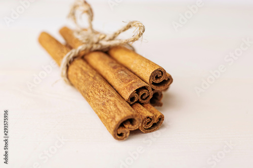 Cinnamon sticks on a white wooden background close-up. The concept of spices for baking, drinks and other dishes. Minimalism, place for text.