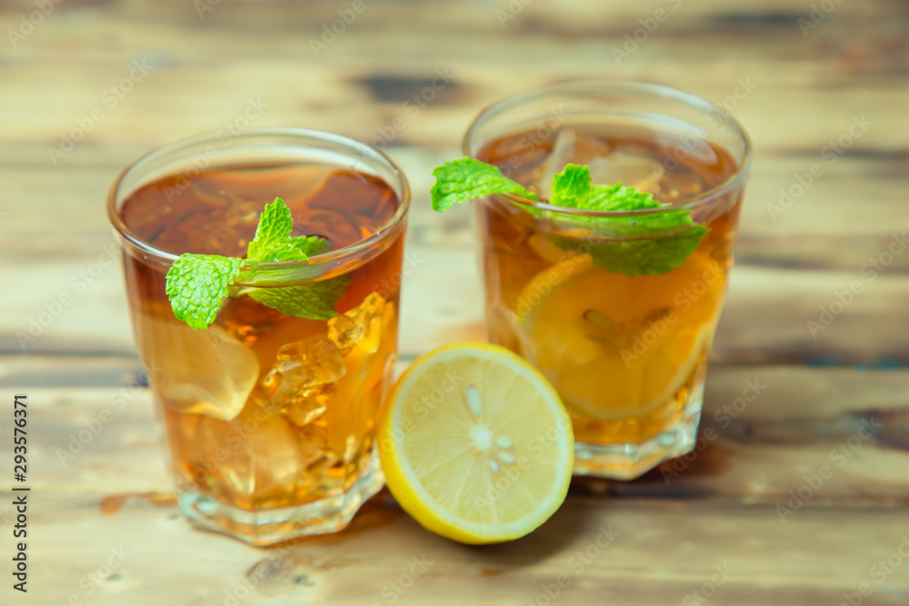 Iced tea with lemon slices and mint on wood background Iced tea with lemon slices and mint on wood background