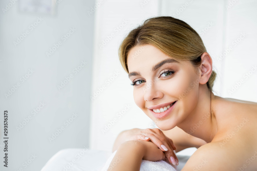 attractive and smiling woman lying on massage mat in spa attractive and smiling woman lying on massage mat in spa