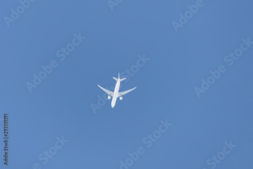 A small passenger plane flies high in the sky