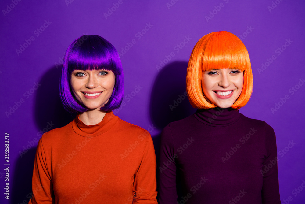 Close-up portrait of two nice-looking attractive lovely pretty charming cute cheerful cheery girls wearing wigs isolated over bright vivid shine vibrant purple violet lilac color background Close-up portrait of two nice-looking attractive lovely pretty charming cute cheerful cheery girls wearing wigs isolated over bright vivid shine vibrant purple violet lilac color background