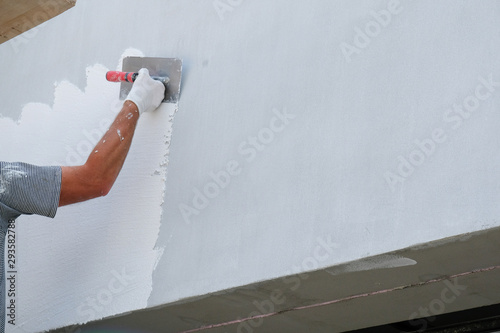 Billede på lærred Painter applying fresh paint on the house facade