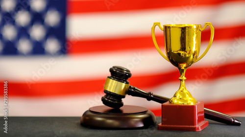 Judge's gavel and trophy USA flag. Symbol for jurisdiction. Law concept a wooden judges gavel on table in a courtroom or law enforcement office photo