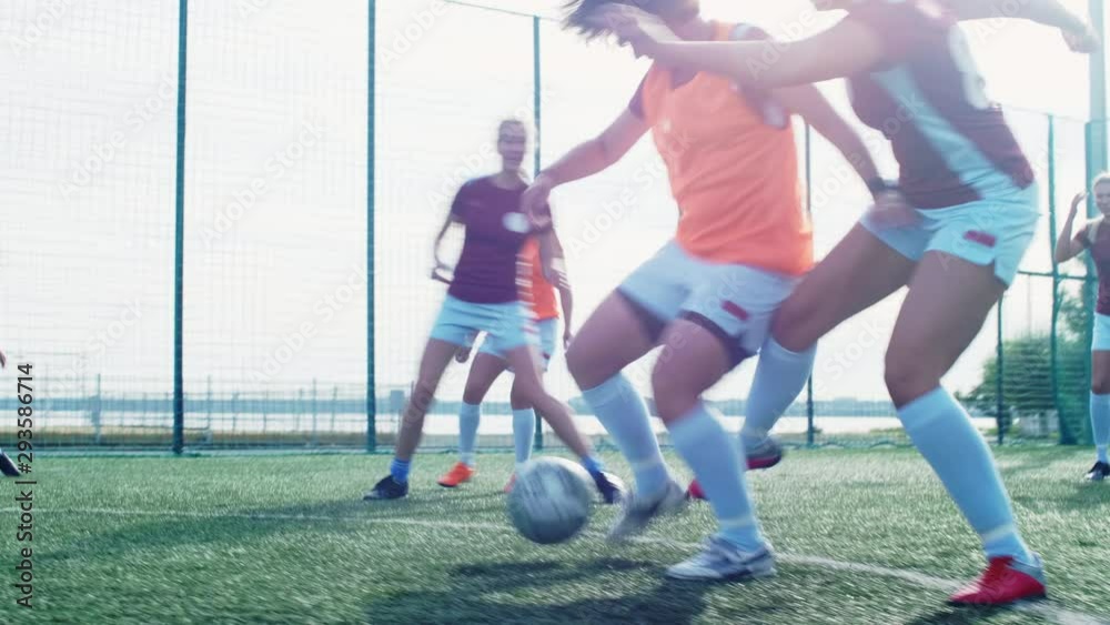 Young women playing professional soccer on outdoor playground in summer