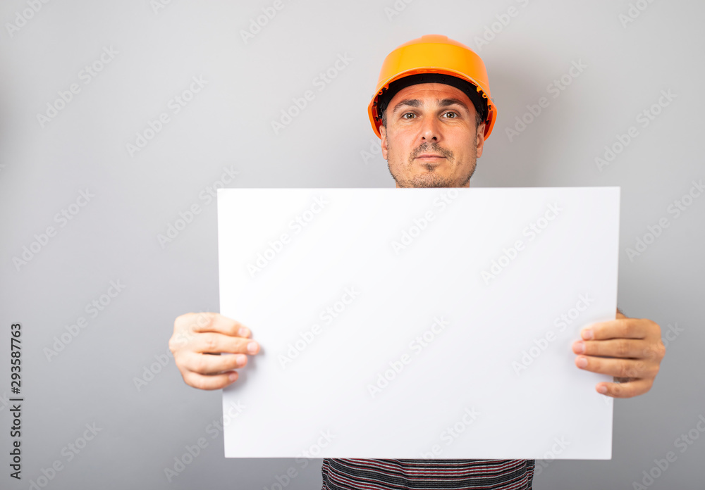 A man in a helmet holds drawings in his hands. A man in a helmet holds drawings in his hands.