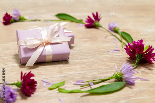 Purple gift boxes. Flowers on a wooden table. Valentine s day concept. Mother s Day Scenery