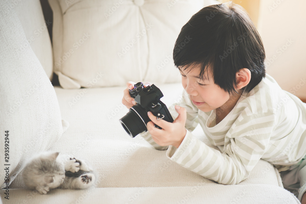 Obraz premium Asian child taking a photo of persian kitten