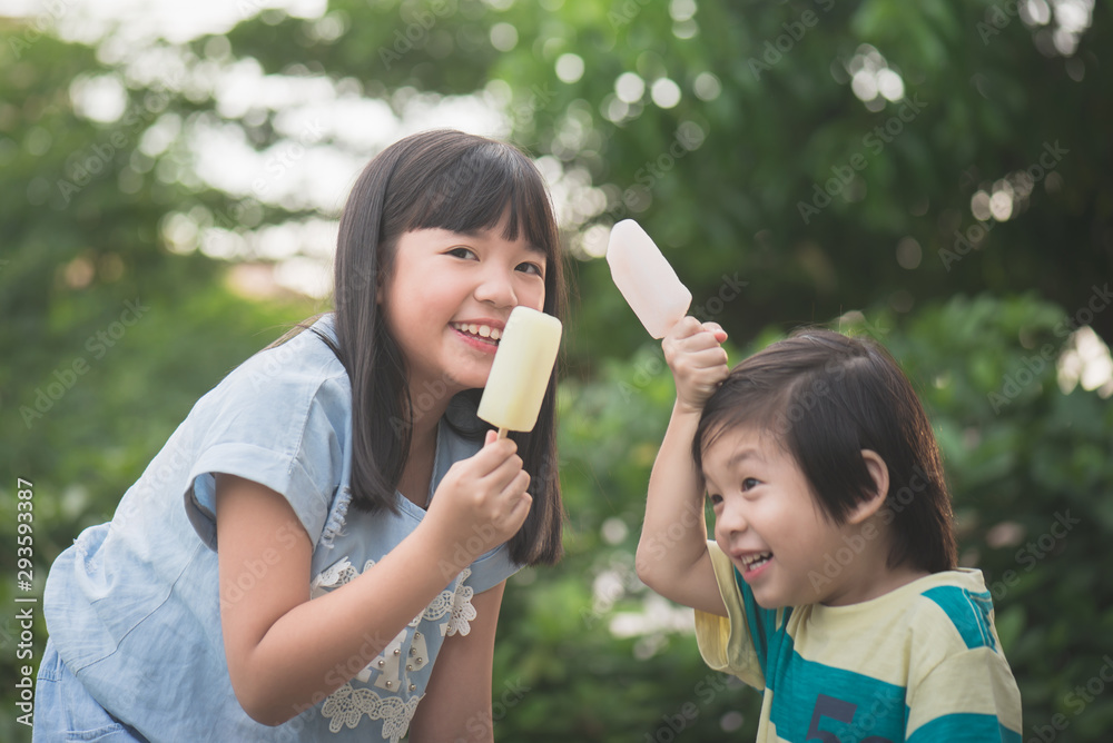 Cute Asian child eating an ice cream outdoors Cute Asian child eating an ice cream outdoors
