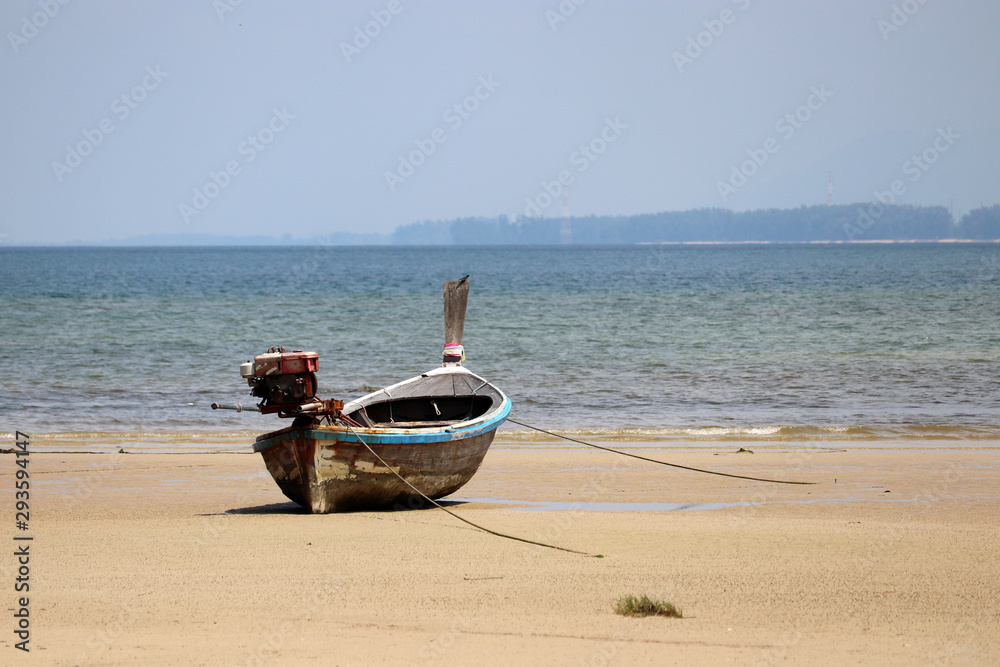 Fishing boat on the sand of tropical beach of Indian ocean. Picturesque seascape in Thailand Fishing boat on the sand of tropical beach of Indian ocean. Picturesque seascape in Thailand