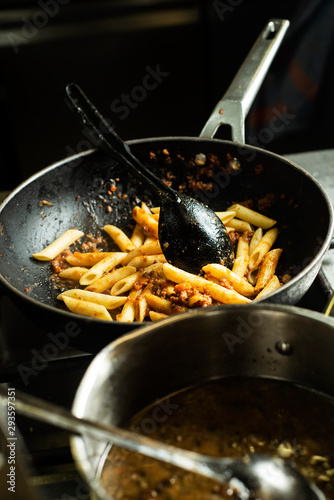 penne rigate in a frypan in a professional kitchen