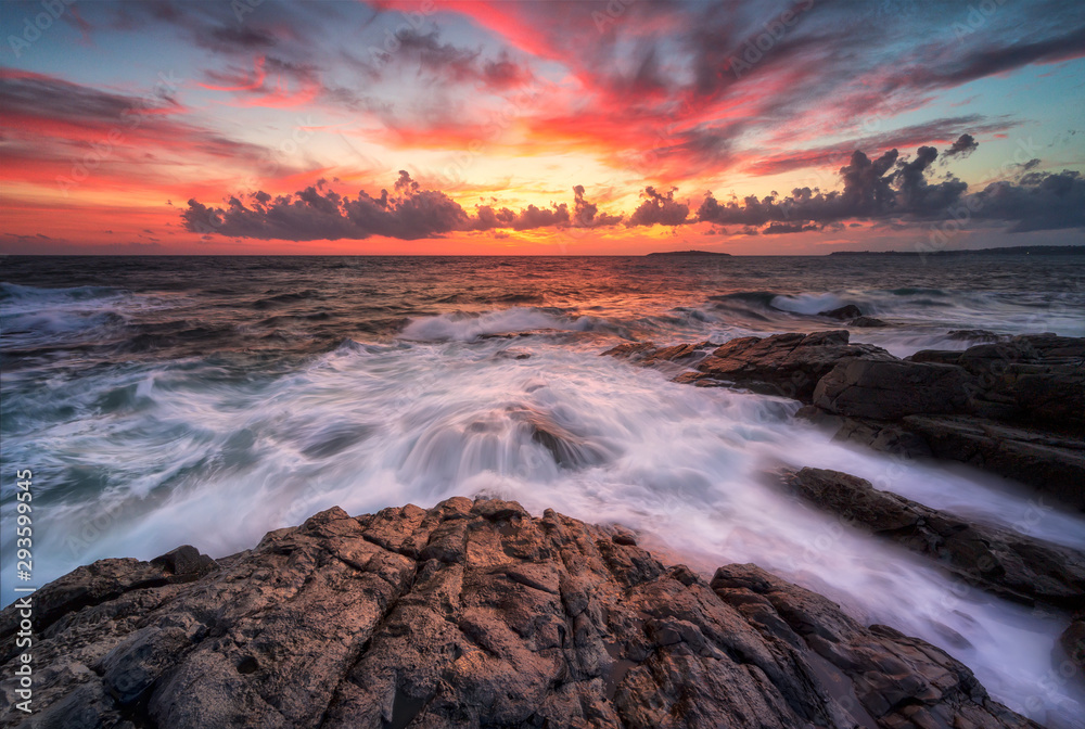 Stormy sea with colorful sunrise sky at the rocky coastline of the Black Sea