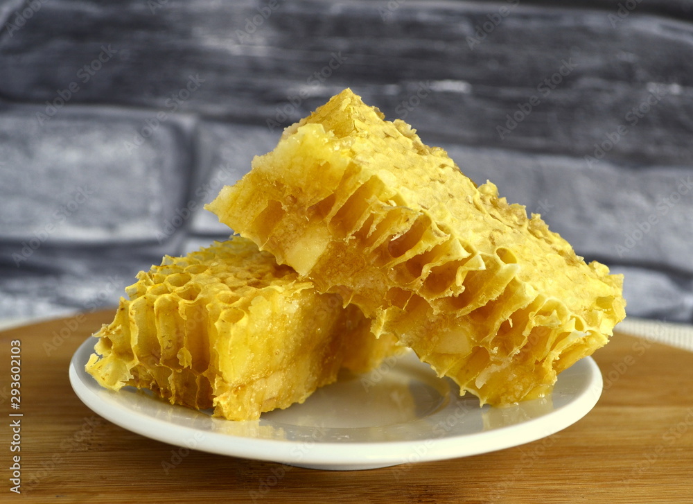 Honeycombs with honey and pollen on a white plate. Honeycombs with honey and pollen on a white plate.