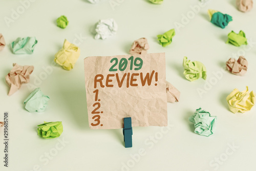 Conceptual hand writing showing 2019 Review. Concept meaning remembering past year events main actions or good shows Colored crumpled paper empty reminder white floor clothespin © Artur