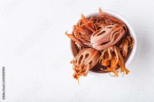 Fotografie Dried whole mace in a bowl on white concrete background close-up with copyspace