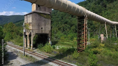 Aerial ascent showing abandoned coaling tower and newer coal slurry pipeline in Whitesville, West Virginia. photo