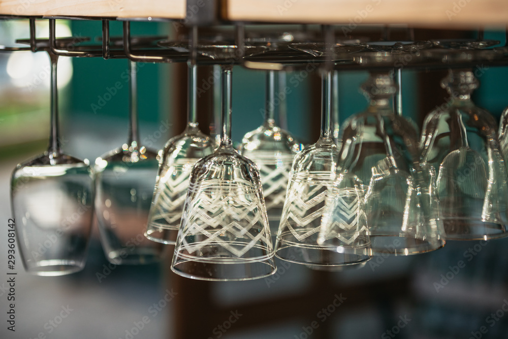 Vintage wine glasses hanging from a bar rack at a small rustic restaurant at sunset