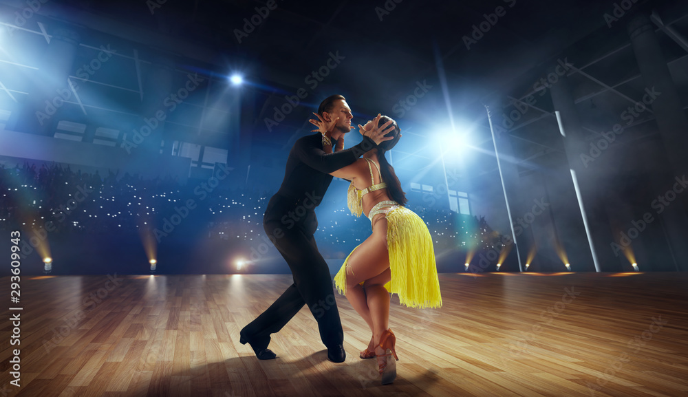 Couple dancers perform latin dance on large professional stage. Ballroom dancing. Couple dancers perform latin dance on large professional stage. Ballroom dancing.