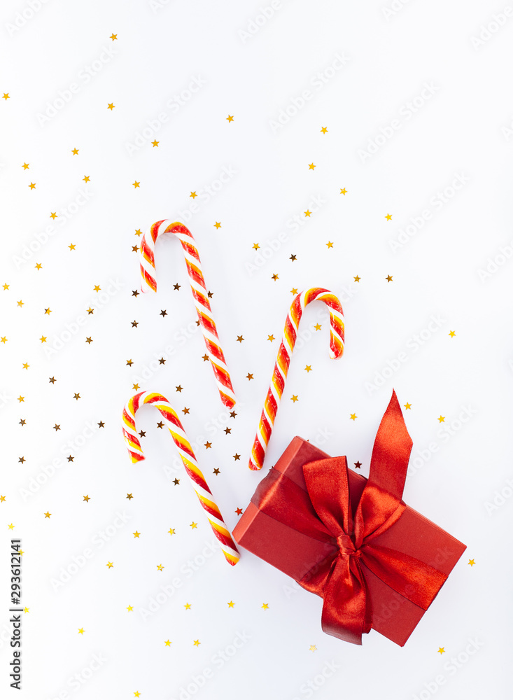 Christmas composition. Candy canes and red gift box on white  background