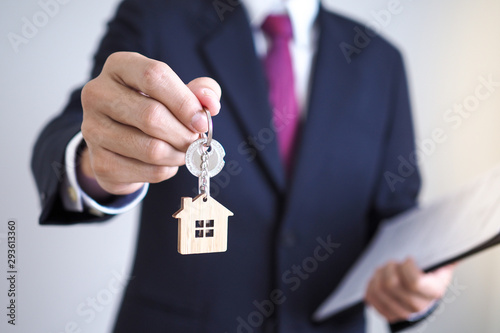 Home sales agents are giving home keys to new homeowners. Landlords and house keys concept