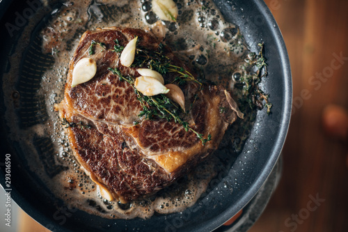 Bilde på lerret Overhead shot of chef preparing ribeye with butter, thyme and garlic