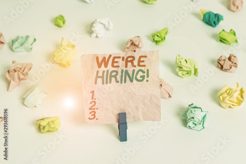 Conceptual hand writing showing We Re Hiring. Concept meaning recently employ someone or pay someone to do particular job Colored crumpled paper empty reminder white floor clothespin © Artur