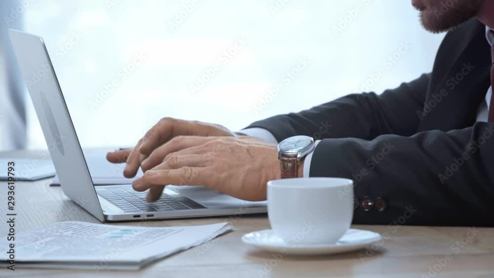 cropped view of businessman typing on laptop, taking off glasses and walking away cropped view of businessman typing on laptop, taking off glasses and walking away