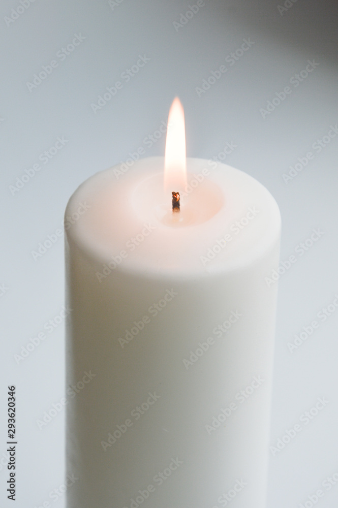 white candle on a light background. white. a large candle. white candle on a light background. white. a large candle.