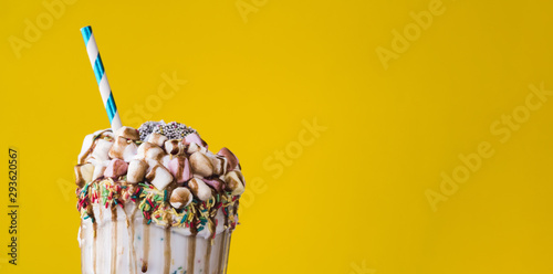 Fotografia Close-up view of delicious milkshake with yellow background