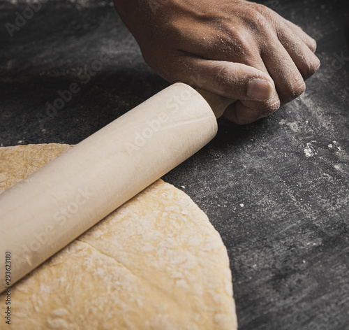 Close-up roller while rolling dough composition photo