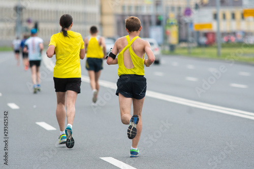Runners on the city road. Sport competitions. Fitness and healthy lifestyle concept