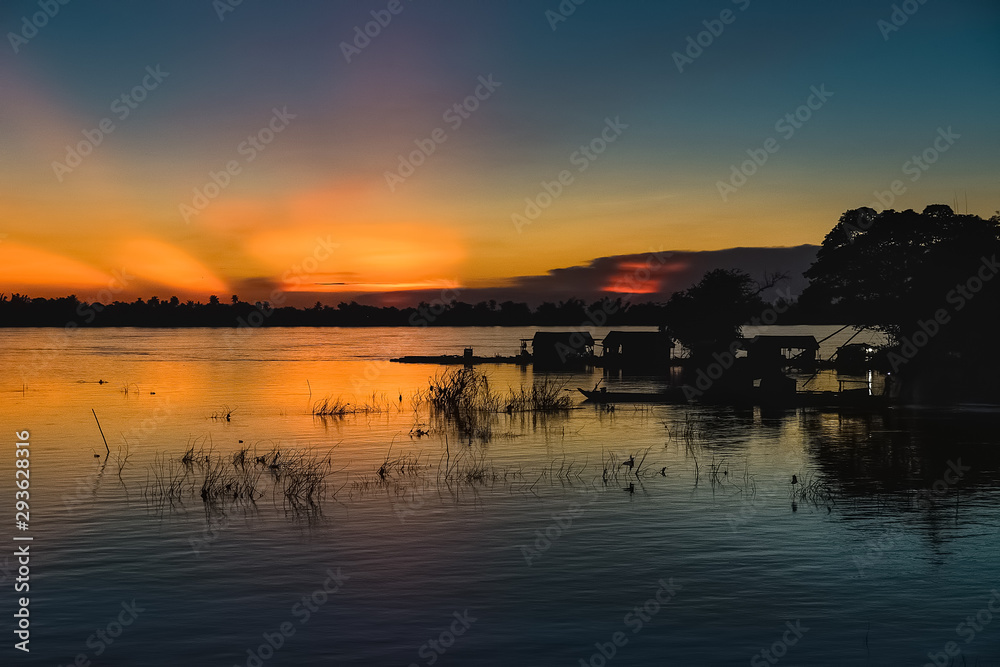 fisherman in a magical sunset in mekong river