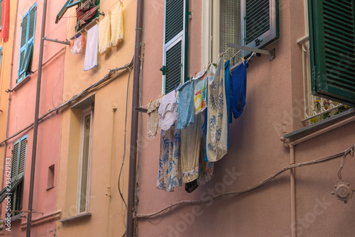 Fototapeta Naklejka Na Ścianę i Meble -  Laundry hanging from front of old houses to dry in Italian street