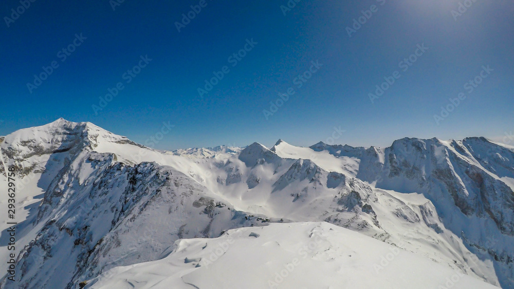 Obraz premium A beautiful and serene landscape of mountains covered with snow. Thick snow covers the slopes. Clear weather. Sharp slopes of the mountains covered with snow, with partially visible rocks.