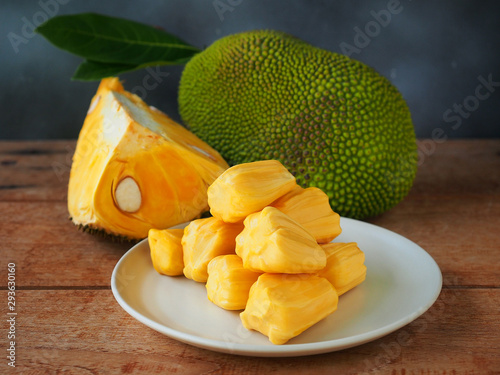 Ripe jackfruit flesh in a white plate on a wooden table for tropical fruit or meat substitute concept. photo