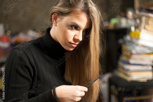 Young woman combing her blond hair in a mess natural skin
