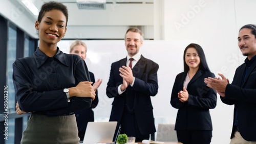 Beautiful African businessman is standing smiling with joy as she has been accepted for good work. Celebrate the promotion With colleagues to congratulate. Joint Venture for Multinational Company