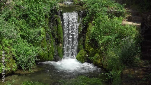 Close up of small waterfall in Provence. Beautiful water cascade with stone steps in french touristic city Moustiers-Sainte-Marie