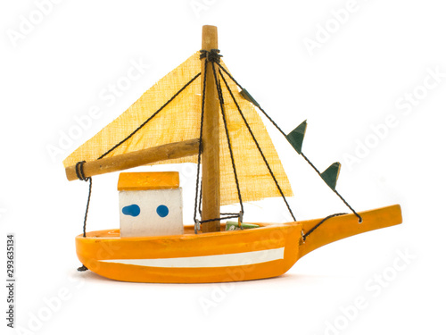 yellow toy small sailing boat on white background photo