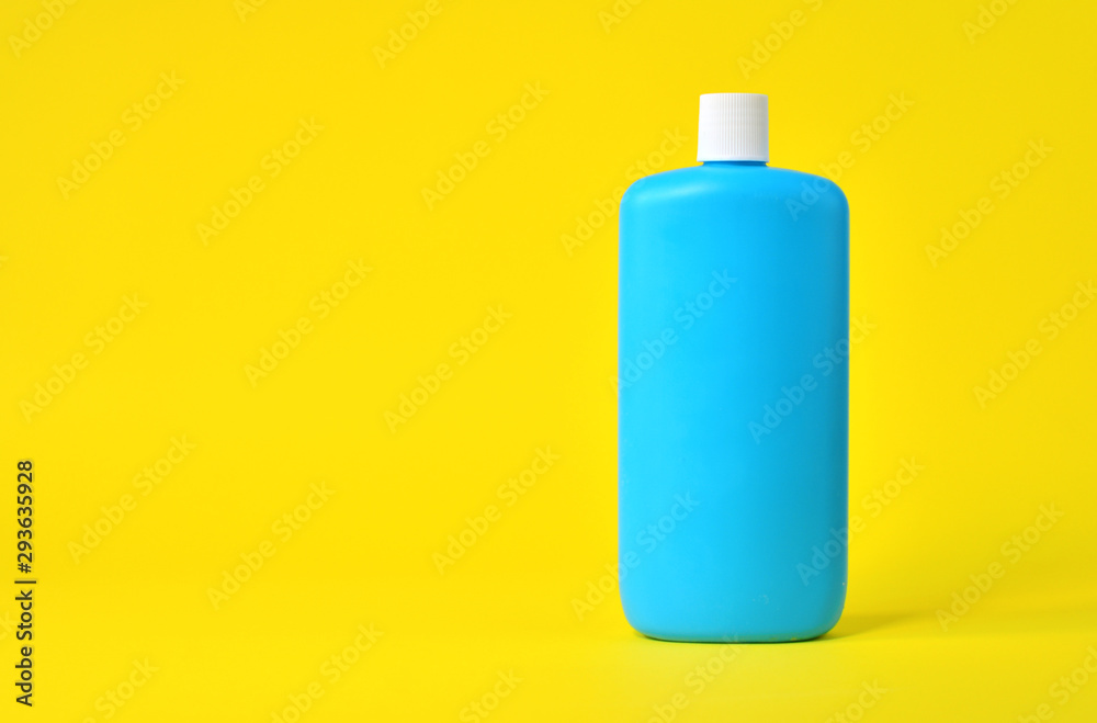 Empty blue plastic bottle on a yellow background Empty blue plastic bottle on a yellow background