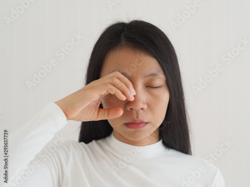 eye socket pain in asian woman cause from the infection of the sinuses cavities or migraines and cluster headaches use for health care concept. photo