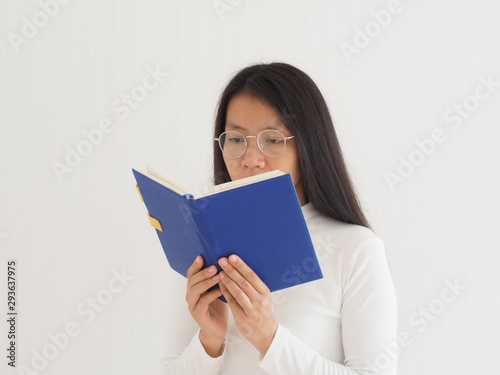 short sighted eye or myopia in asian woman read a blue book and wearing glasses cause of distant objects to blurred, while close objects can be seen clearly, treatment of laser eye surgery.