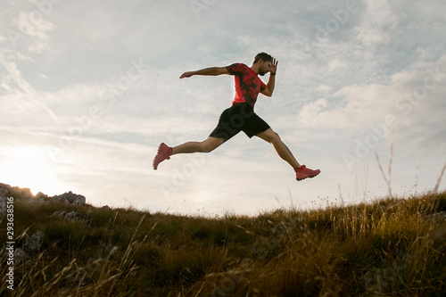 Trail running man jumping in the sky