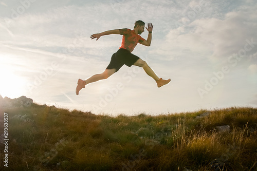 Trail running man jumping in the sky