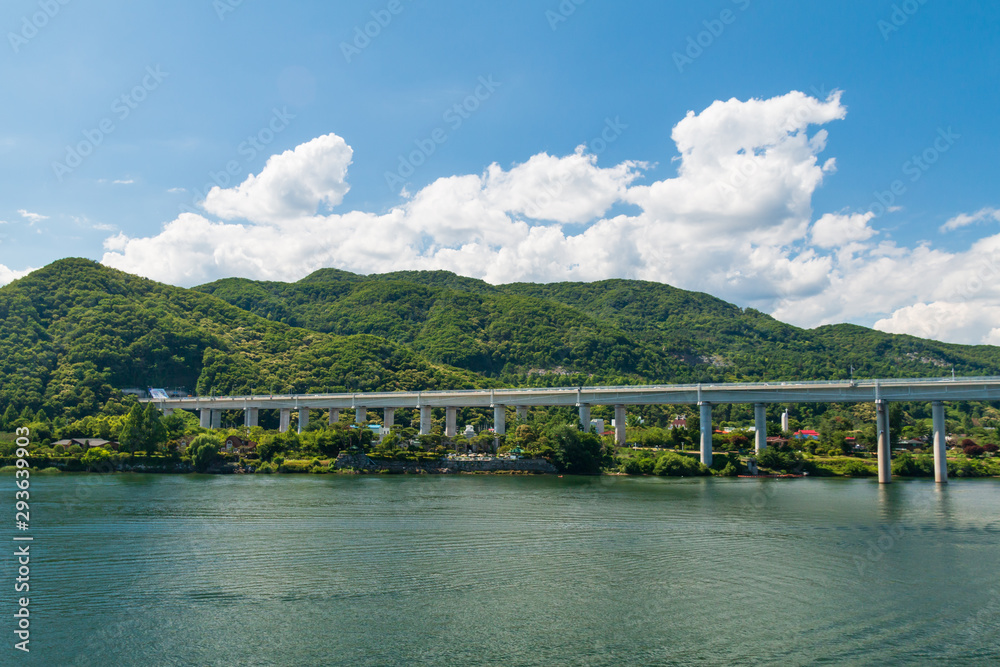 landscape of river with bridge under blue clear sky