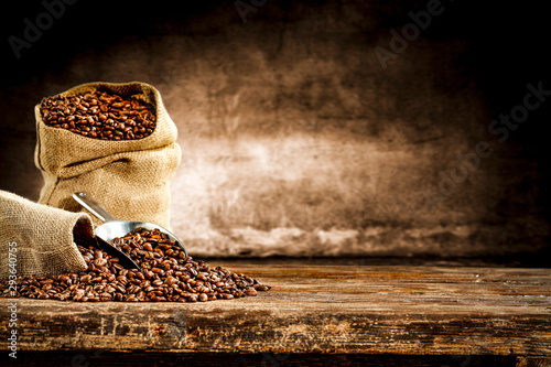Fototapete Fresh old sack of coffee grains and brown old wall background
