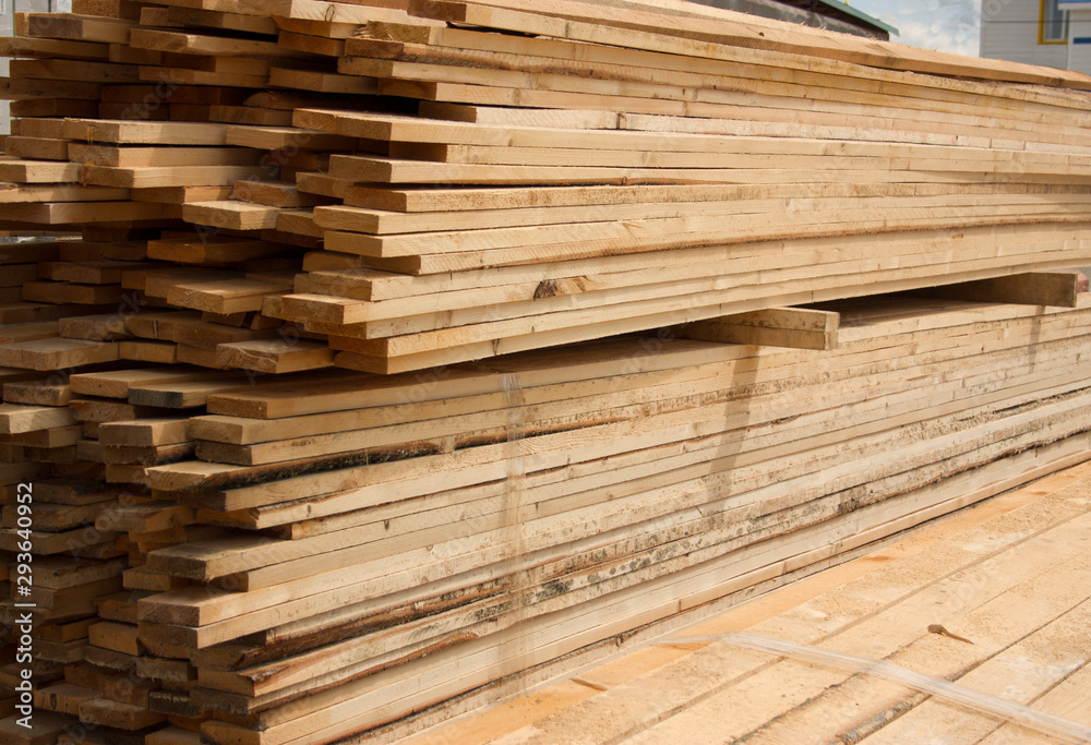 Lumber warehouse. Long wood planks stacked outdoors Lumber warehouse. Long wood planks stacked outdoors