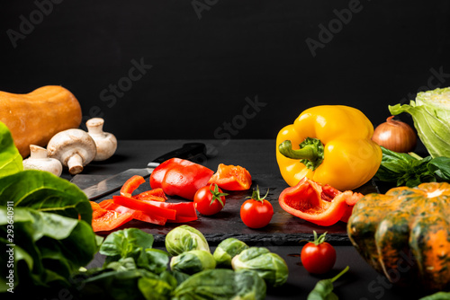 Different fresh vegetables on a black background. Healthy vegetarian food. Copy space for text.